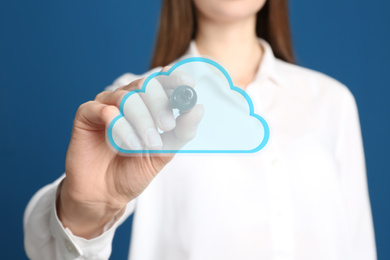 Woman pointing at virtual cloud icon on blue background, closeup of hand. Data storage concept