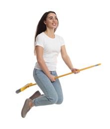 Beautiful young woman with broom jumping on white background