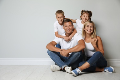 Photo of Happy family with children near grey wall. Space for text