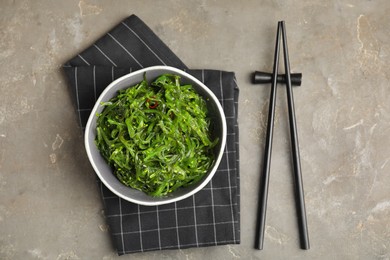 Japanese seaweed salad served on grey table, flat lay