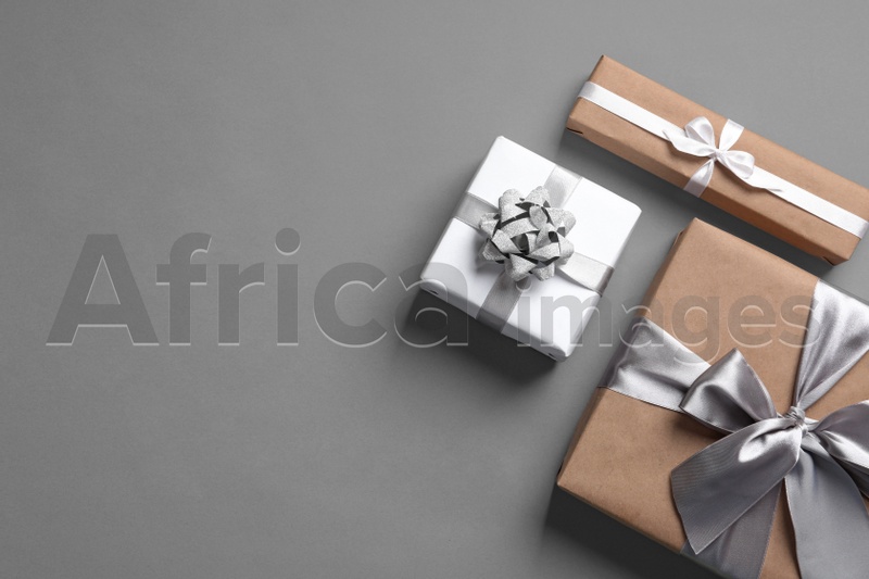 Beautifully wrapped gift boxes on grey background, top view