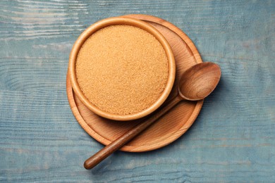 Photo of Brown sugar in bowl on light blue wooden table, top view