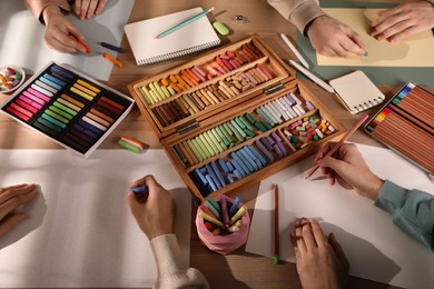 Artists drawing with soft pastels and pencils at table, above view