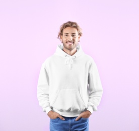 Photo of Portrait of man in hoodie sweater on color background. Space for design