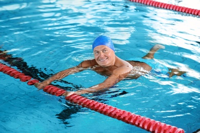 Sportive senior man in indoor swimming pool