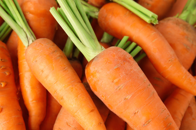 Fresh ripe carrots as background, closeup view