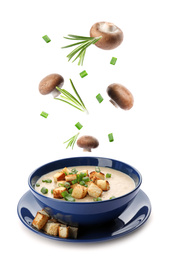 Many different ingredients falling into bowl with homemade mushroom soup on white background