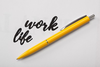 Text Work, Life and pen on white background, top view. Balance concept