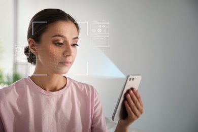 Young woman unlocking smartphone with facial scanner indoors. Biometric verification