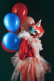 Terrifying clown with air balloons on black background. Halloween party costume