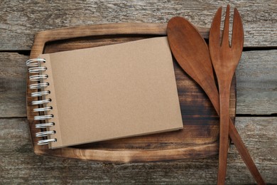 Photo of Blank recipe book and kitchen utensils on old wooden table, flat lay. Space for text