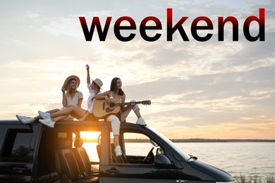 Hello Weekend. Happy friends with guitar sitting on car roof outdoors at sunset