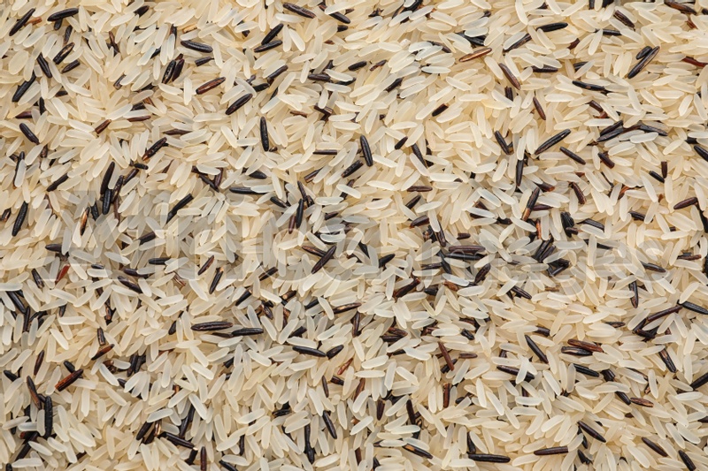 Mix of different brown and polished rice as background, top view