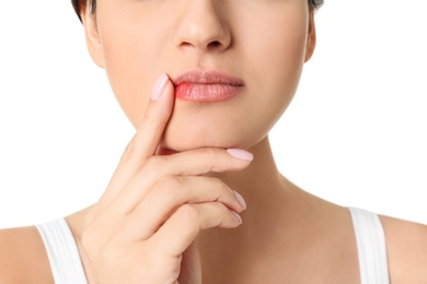 Woman with cold sore touching lips on white background, closeup