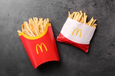 MYKOLAIV, UKRAINE - AUGUST 12, 2021: Small and big portions of McDonald's French fries on grey table, flat lay