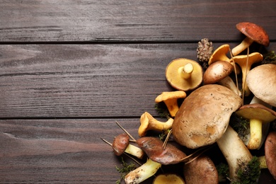 Flat lay composition with fresh mushrooms on wooden table, space for text