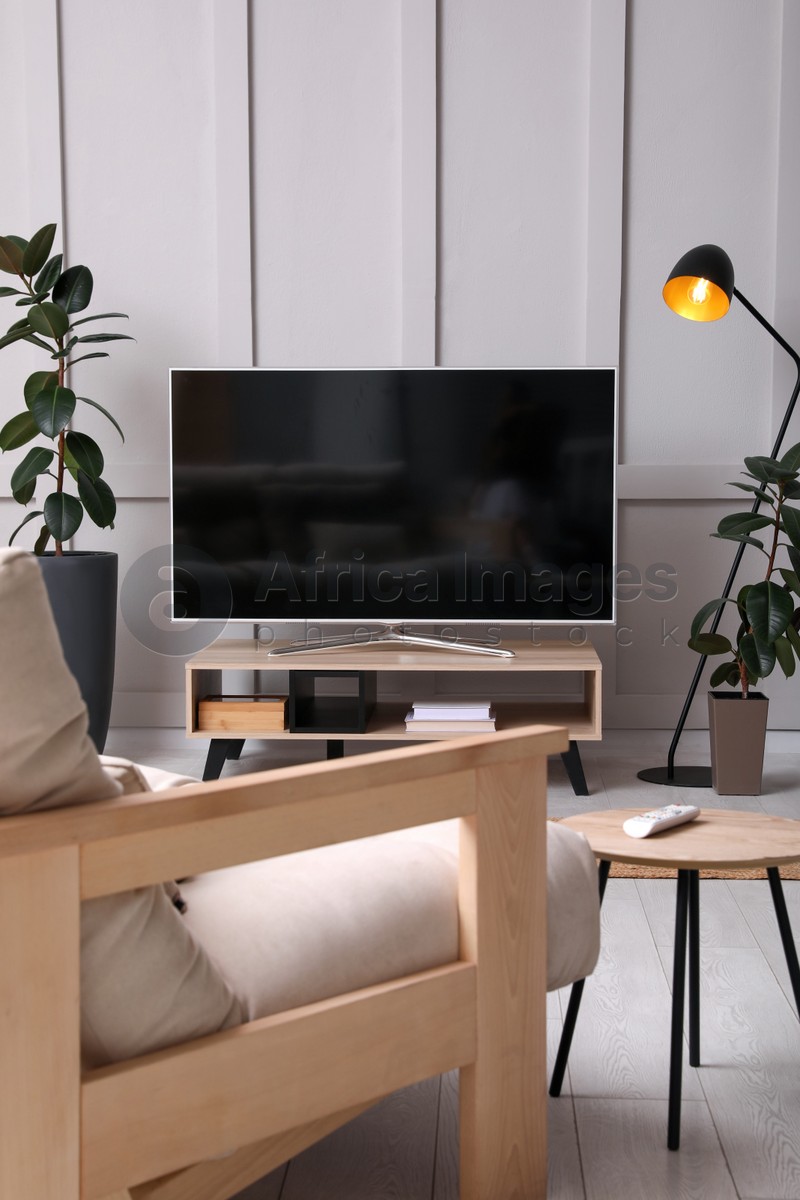 Photo of Stylish room interior with TV on wooden cabinet