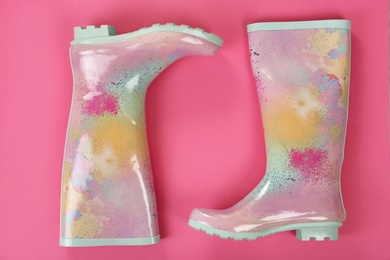 Pair of gumboots on color background, top view. Female shoes