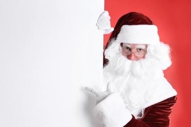 Santa Claus holding empty banner on red background