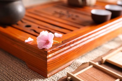 Tray for traditional tea ceremony with sakura flower on table, closeup