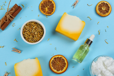 Flat lay composition with natural handmade soap and ingredients on light blue background