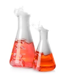 Photo of Laboratory flasks with colorful liquids and steam isolated on white. Chemical reaction