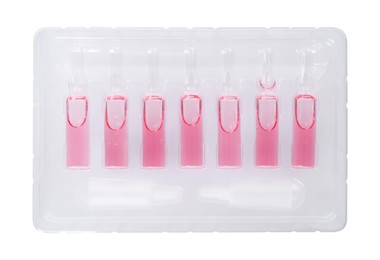 Glass ampoules with pharmaceutical product in tray on white background, top view