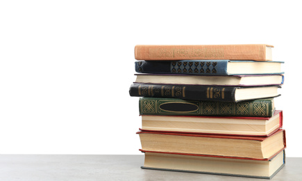 Stack of old vintage books on stone table against white background