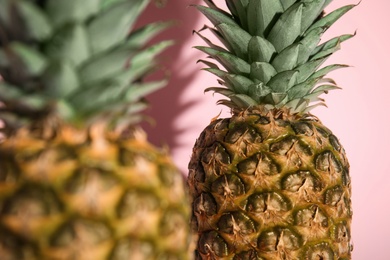 Photo of Fresh ripe juicy pineapples on pink background, closeup