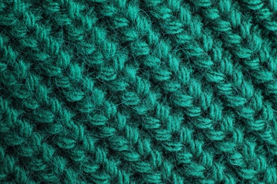 Green knitted sweater as background, closeup view