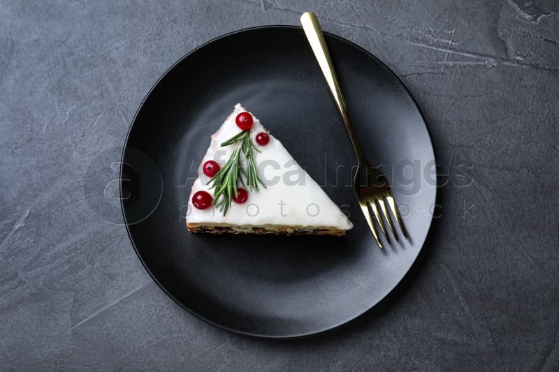 Photo of Slice of traditional Christmas cake served on black table, top view