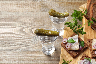 Cold Russian vodka with snacks on wooden table, above view