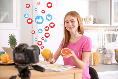 Cute teenage blogger with fruits recording video at table