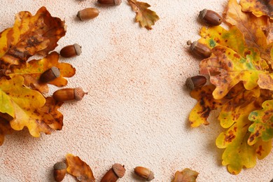 Frame of autumn leaves and acorns on color background, flat lay. Space for text