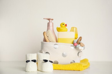 Baby booties and accessories on table against white background