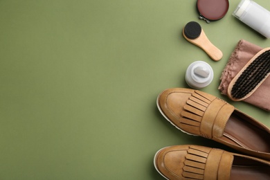 Flat lay composition with shoe care accessories and footwear on green background. Space for text