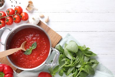 Delicious tomato sauce on white wooden table, flat lay. Space for text