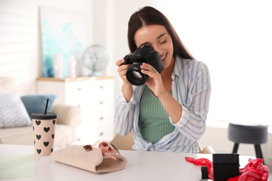 Photo of Young photographer taking picture of accessories indoors