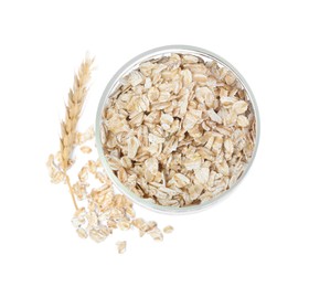 Raw oatmeal, glass jar and spikelet on white background, top view