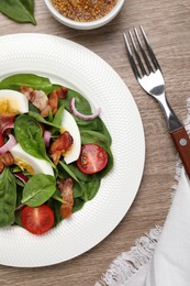 Photo of Delicious salad with boiled egg, bacon and vegetables served on wooden table, flat lay