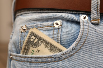 Dollar banknote in pocket of jeans, closeup. Spending money