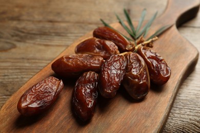 Branch of sweet dried dates on wooden table, closeup