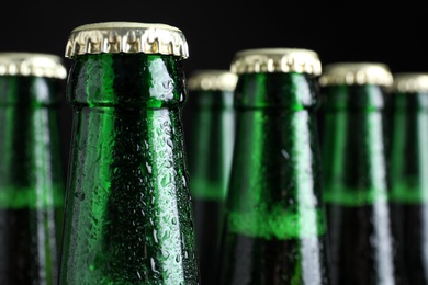 Photo of Bottles of beer on dark background, closeup. Space for text
