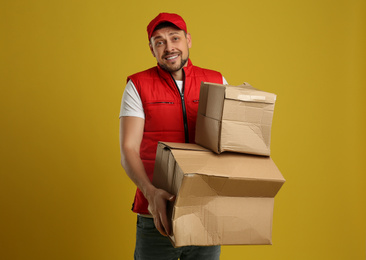 Courier with damaged cardboard boxes on yellow background. Poor quality delivery service