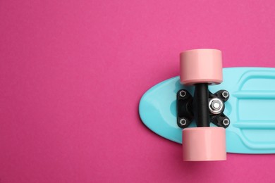 Skateboard on crimson background, top view. Space for text
