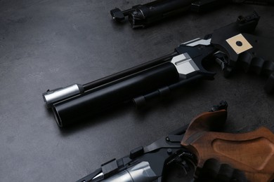 Different sport pistols on black table. Professional guns
