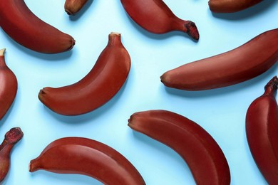 Tasty red baby bananas on light blue background, flat lay