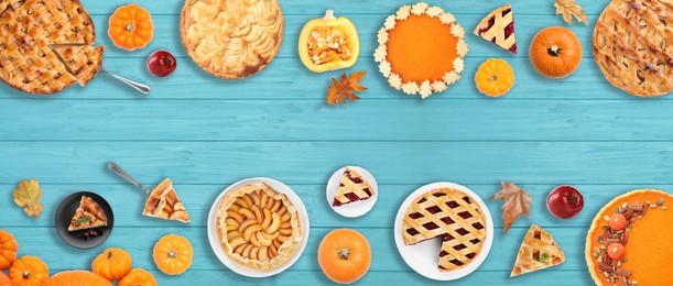 Flat lay composition with different tasty pies on blue wooden table. Banner design