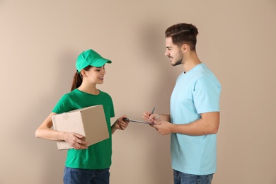 Client receiving parcel from delivery service courier on color background