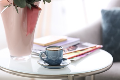 Cup of coffee and magazines on table